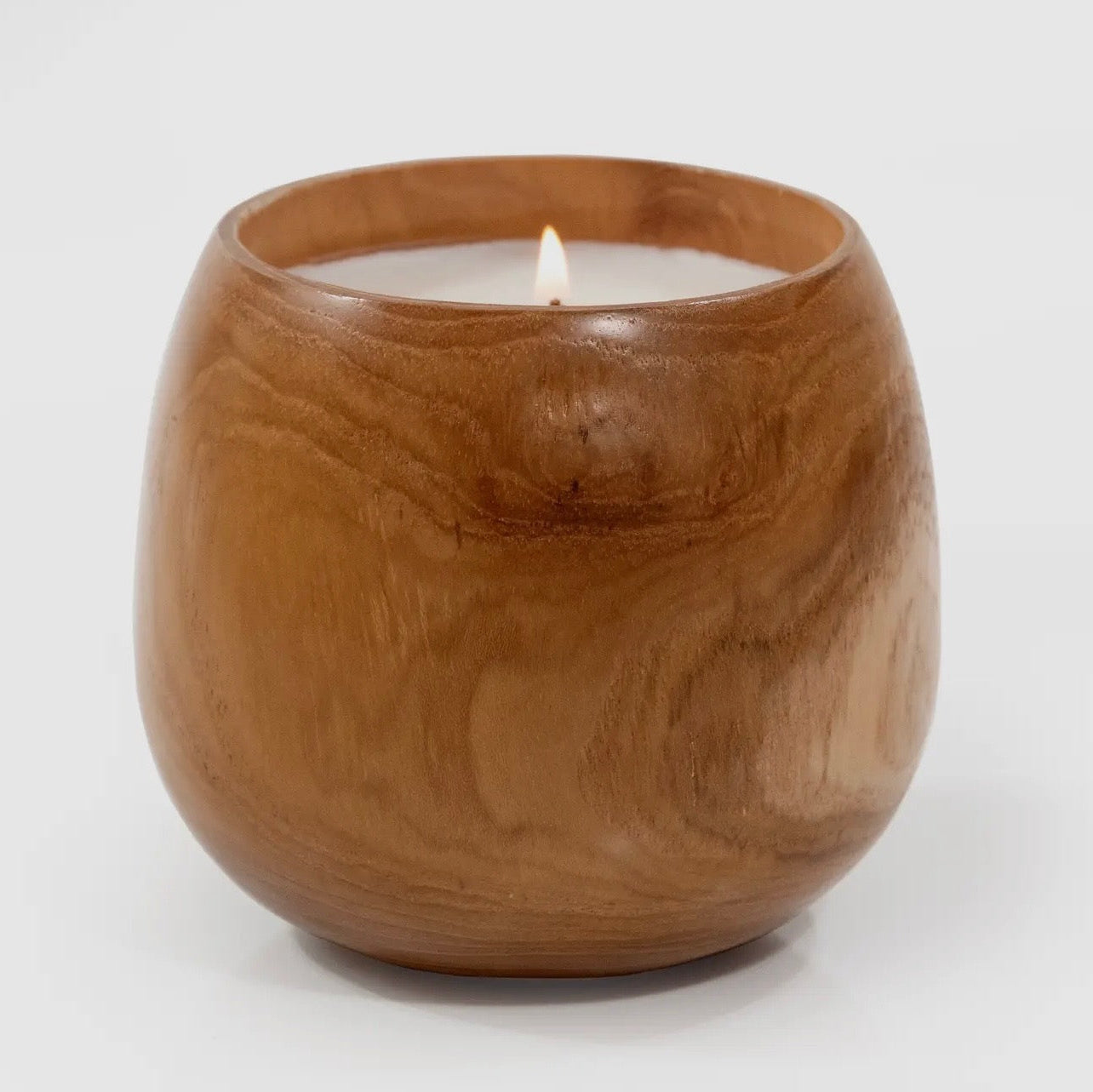 Wooden candle holder with a lit candle on a white background