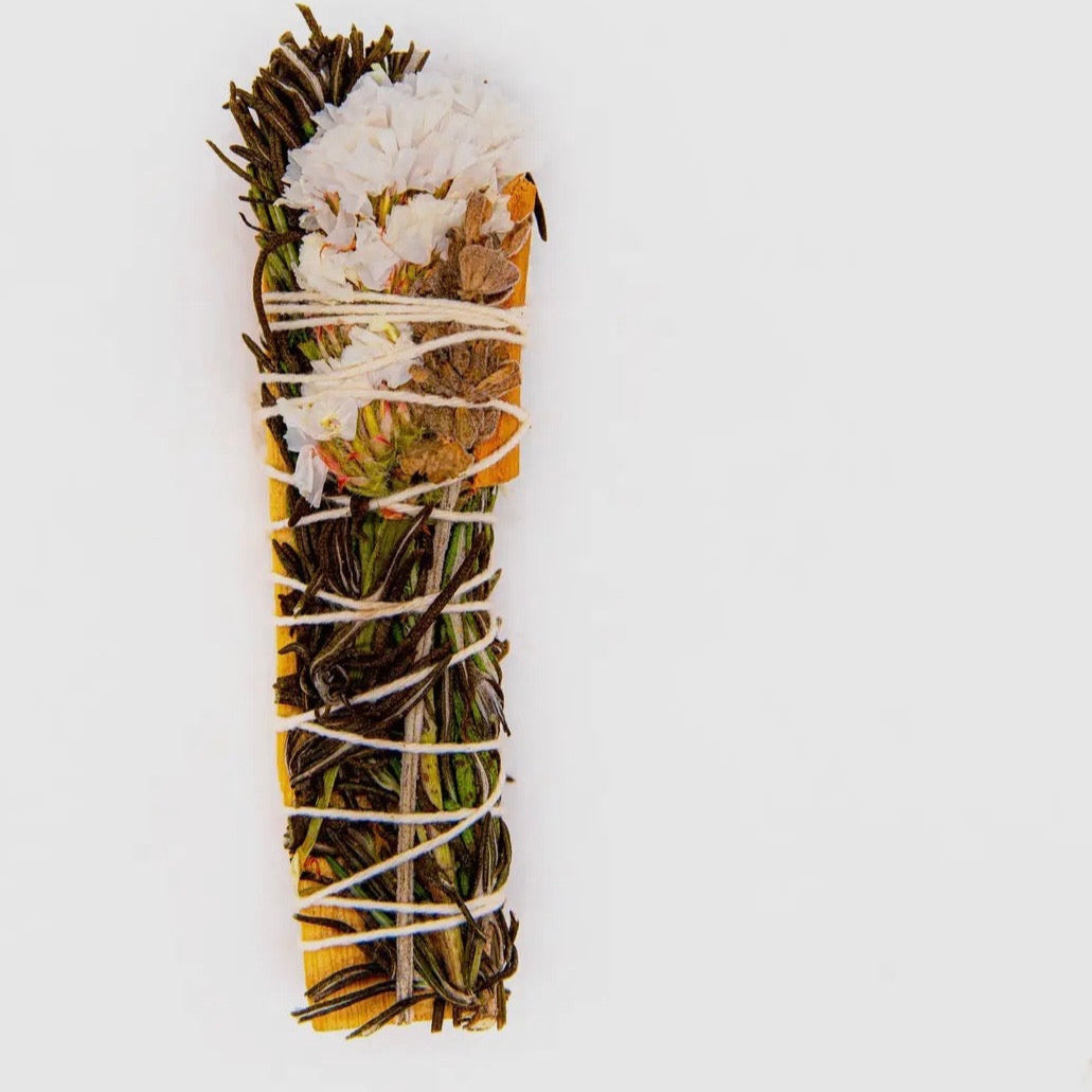 Sage bundle with white flowers on a light gray background